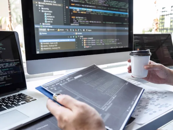 Web developer writing code on a desktop monitor
